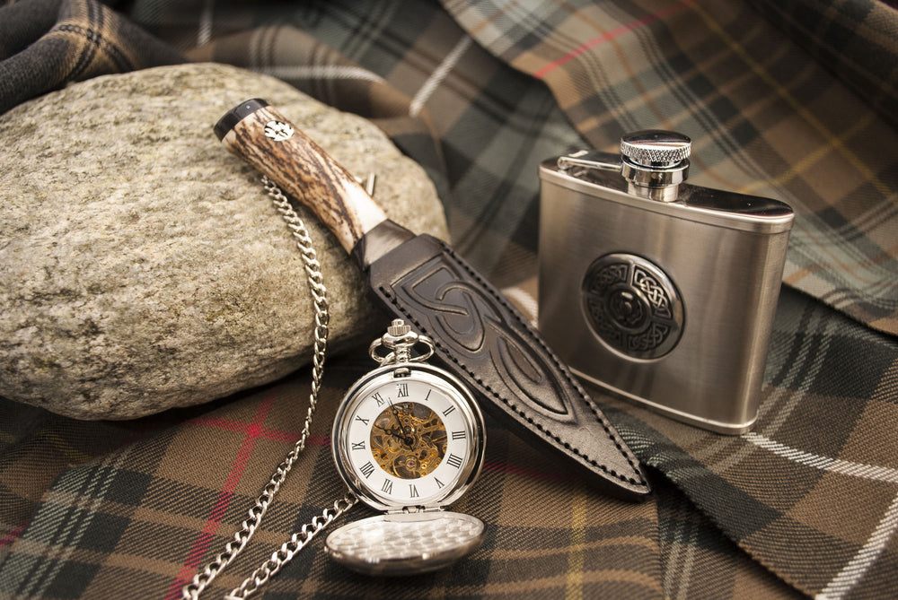 sgian dubh with silver pocket watch and pewter hip flask on weathered tartan